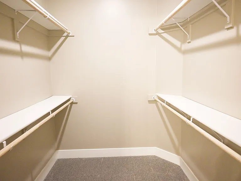Large walk-in closet with clothing racks.