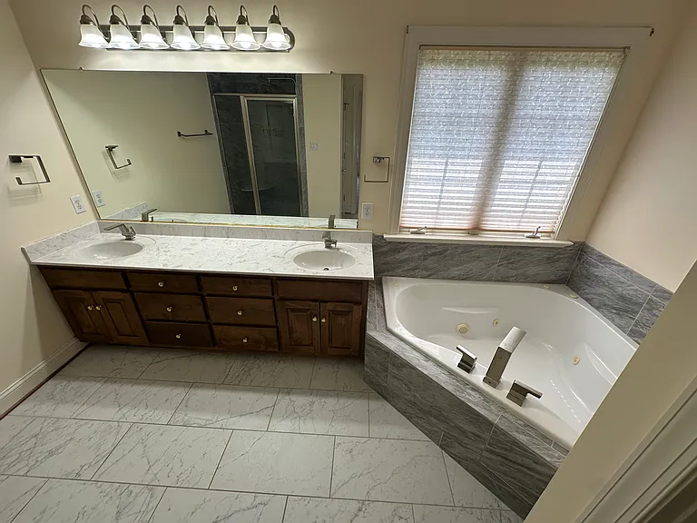 Primary bathroom with tile floor, double vanity and jetted tub