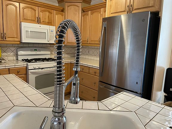 Kitchen has ample cabinets & counterspace, open to living & dining room