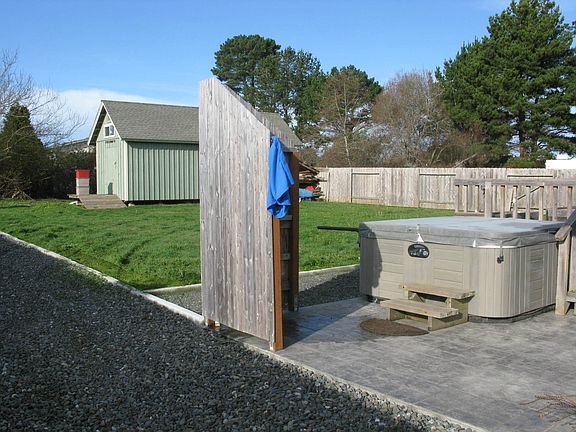 Large fenced backyard with hot tub, outdoor shower & storage building