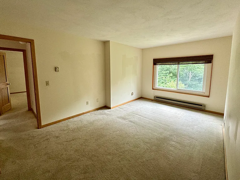 Spacious second bedroom overlooking the backyard with a view of the woods leading to Second dam