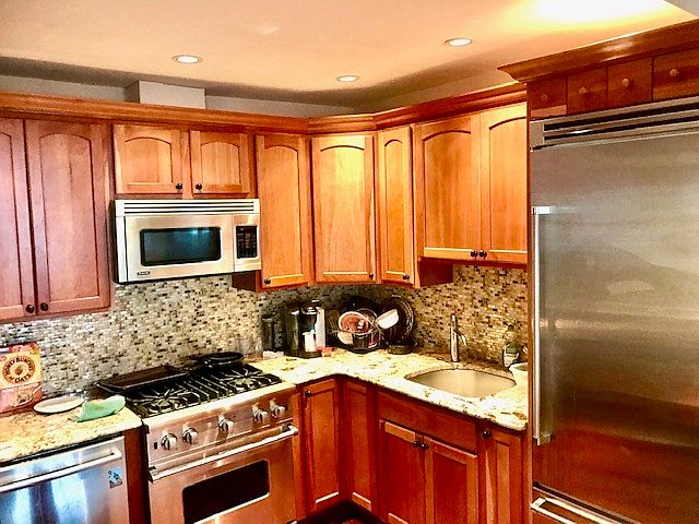 Kitchen with Viking stove and refrigerator, granite counter tops and Bosch dishwasher. Cherry cabinets