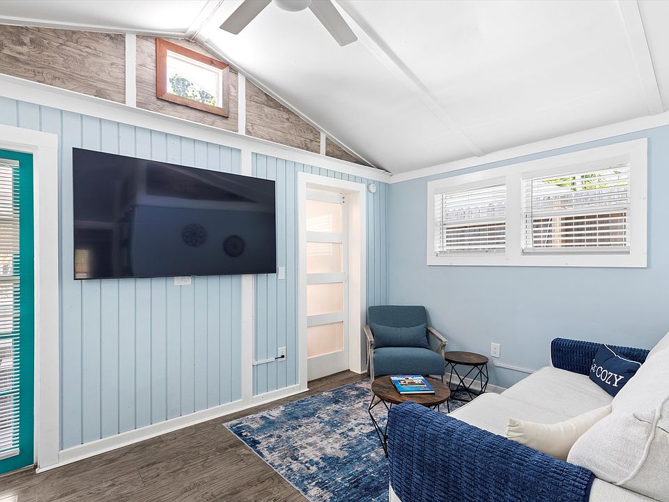 Living room with vaulted ceilings and large flat screen tv.