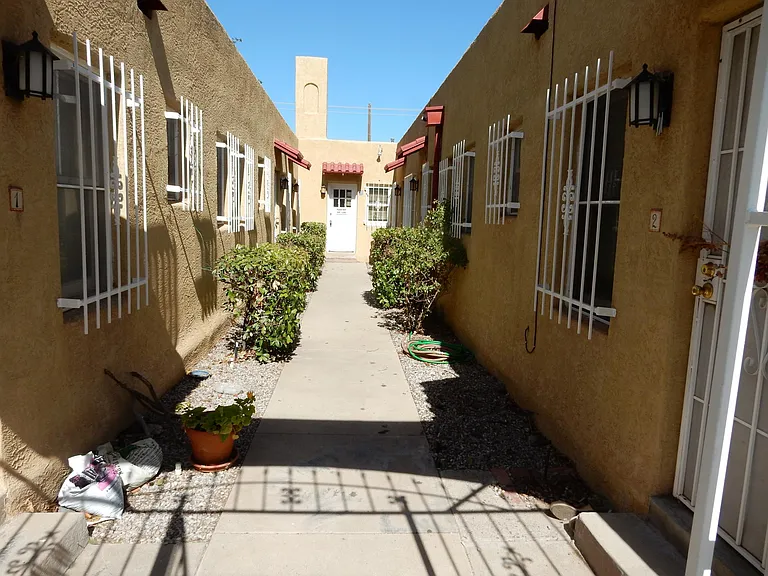 The apartment is on the right side of the building, and the laundry room is on the end of the sidewalk
