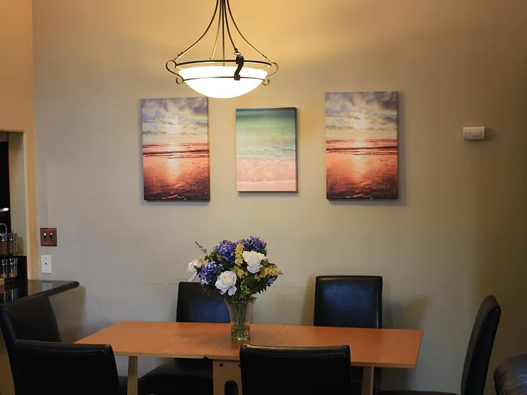 Cathedral ceilings with windows at the top creates spaciousness and light in the dining area. Dining room table with leather chairs.