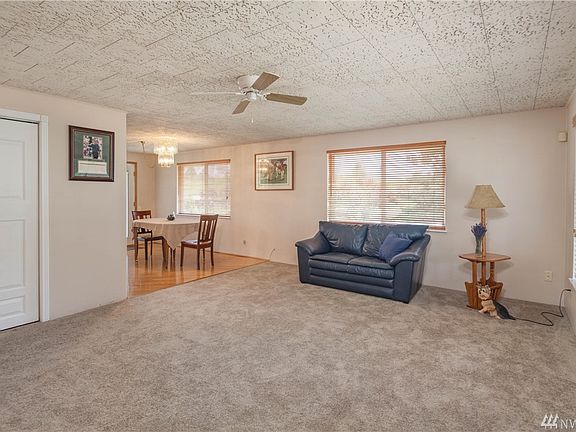 The living room is carpeted, and cooled by a light/ceiling fan.