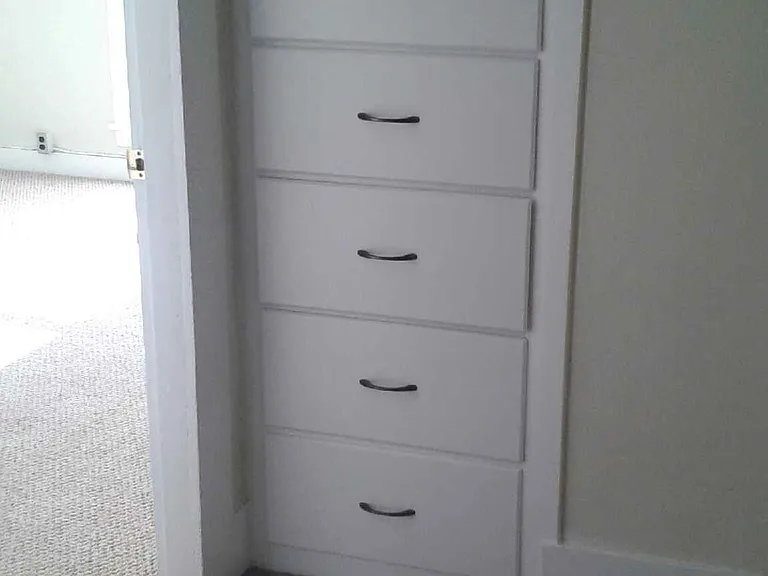 At the end of the hallway, near the main bedroom are shelves. There is also a closet in the hallway near the kitchen.