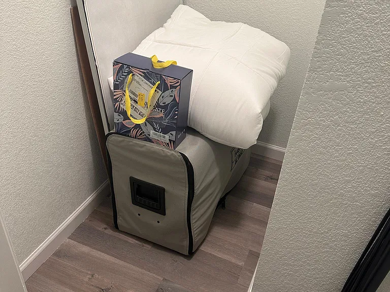 Self-inflating queen size bed in study closet with sheets and comforter.