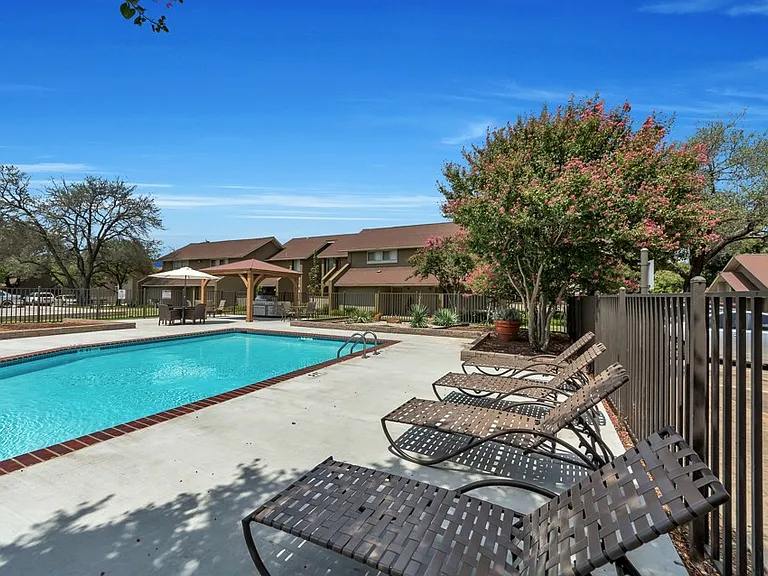 Sparkling community pool with sun deck and relaxing lounge chairs for residents