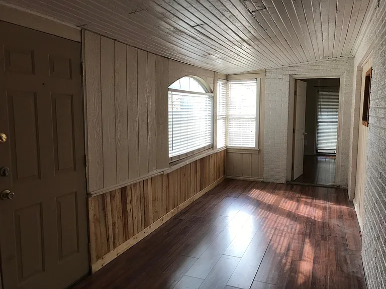 East bedroom has lots of windows for natural light and door to exterior yard