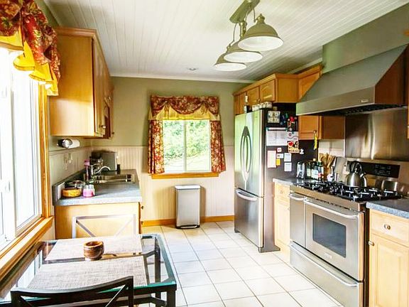 The newer kitchen is an excellent space with maple cabinets, stainless steel appliances, including a professional grade range/oven, ideal large pantry, newer lighting, extra closet and ceramic tile floors