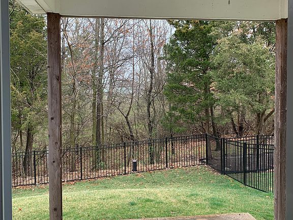 View from sliding glass doors off of dining area looking at covered patio and fenced back yard.