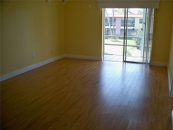 Living room with laminate flooring and sliding glass doors to balcony overlooking the golf course