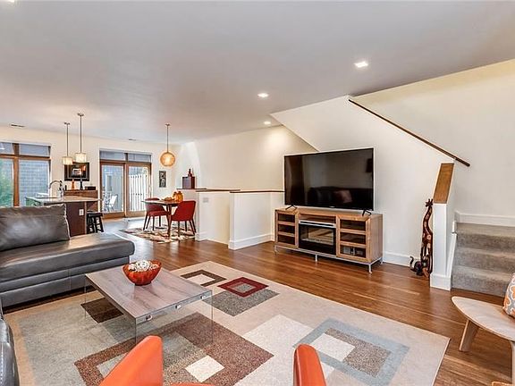 Another view of the main living area shows the sliding glass doors that lead to a deck and the dining area, currently set for tw