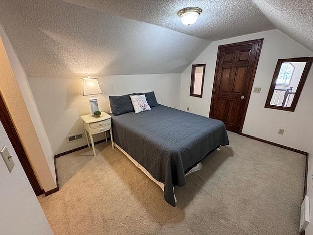 Upper level Bedroom shown, includes sitting area in loft outside closed door, spacious closets on both sides of the hallway to private bathroom.