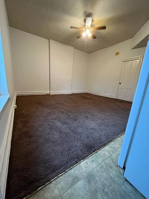 Open concept living room//kitchen with large ceiling fan.