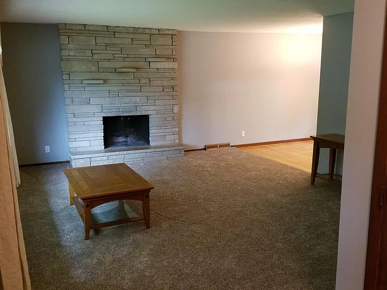 Main floor living room with new carpet and wood burning fire