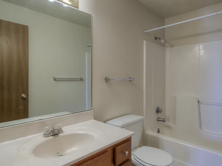 Bathroom with lighting at Huntington Apartments.