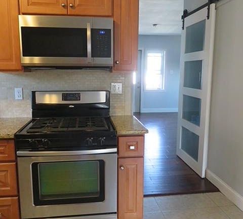 Kitchen looking into living area; pantry door on right