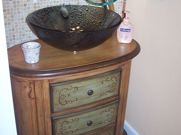 Half bath with custom vanity and  bowl sink with onyx tile wall