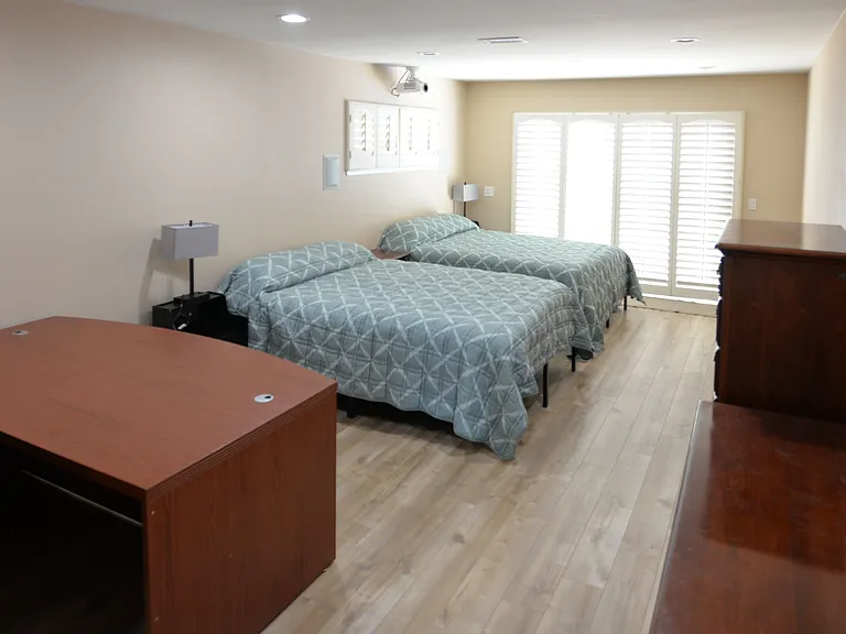 Large master bedroom with direct access to spa/pool area. Ceiling mounted projector with in-wall surround sound speakers for home theater experience.