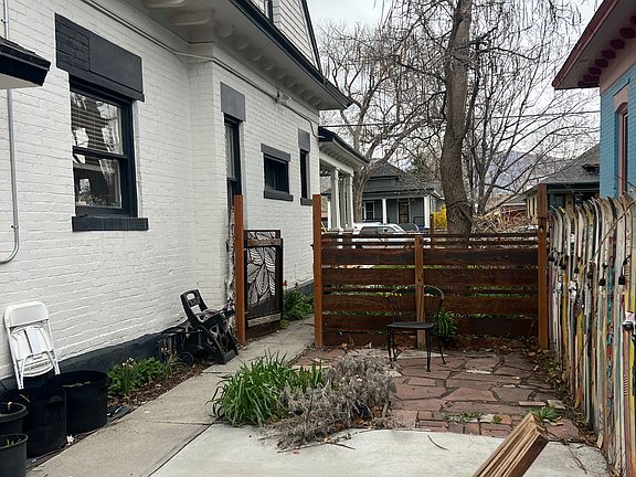 Private back patio with ski fence, greenhouse and gate to private parking