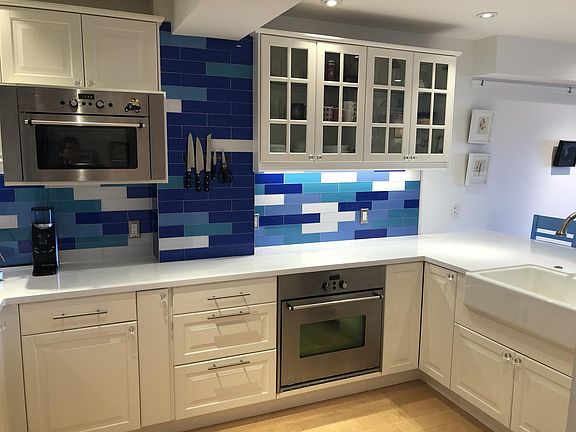 Gourmet kitchen with white corian counters and custom tiles