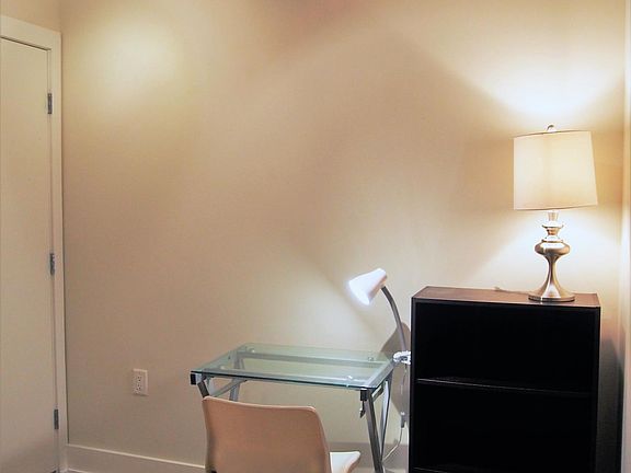Den with a study desk, bookshelf, washer/dryer, and closet