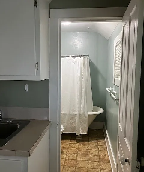Bathroom with claw foot tub and shower off kitchen