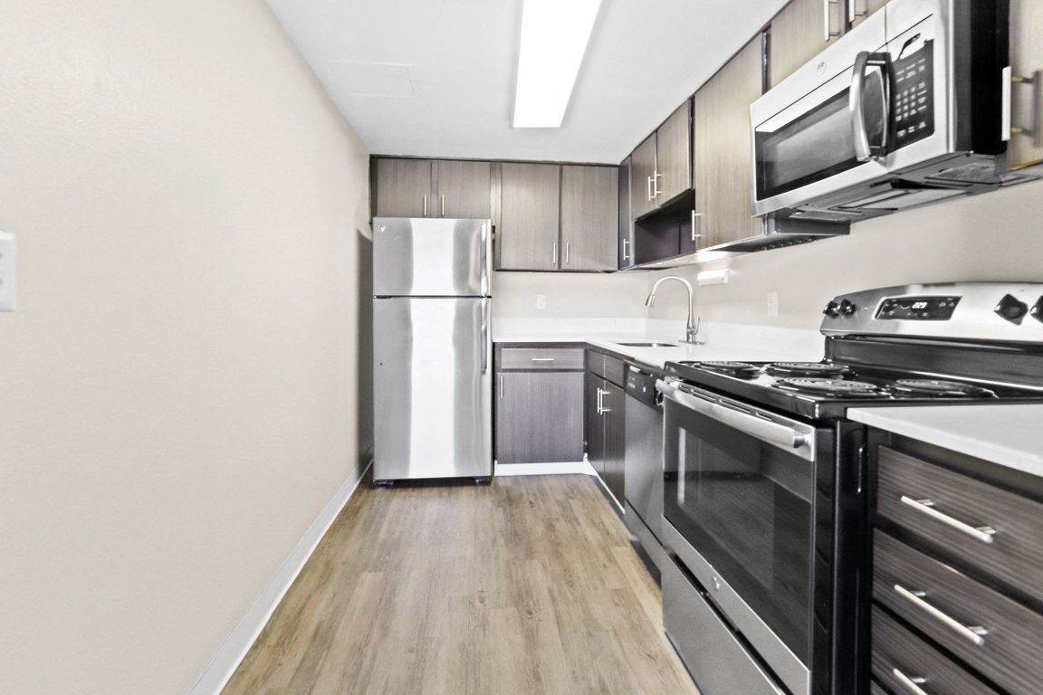 Updated kitchen with sleek stainless appliances and wood flooring