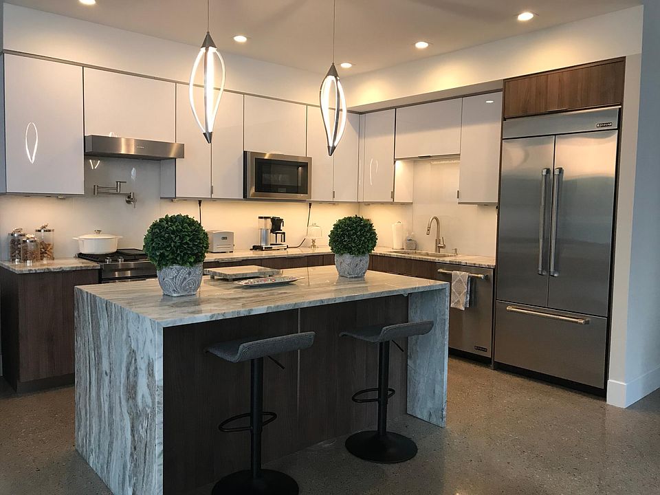 Gourmet kitchen with high-end appliances, including 36" wine fridge, premium granite countertops, custom glass backsplash, dual pull-out trash cans and pot filler.