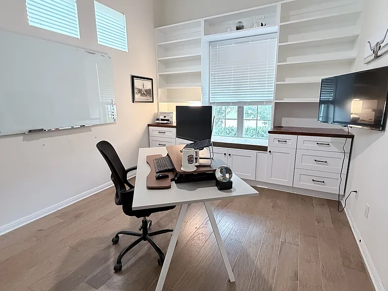 Office with built-in cabinets and shelving.