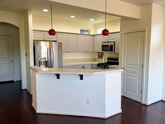 Open kitchen featuring stainless appliances and peninsula seating.