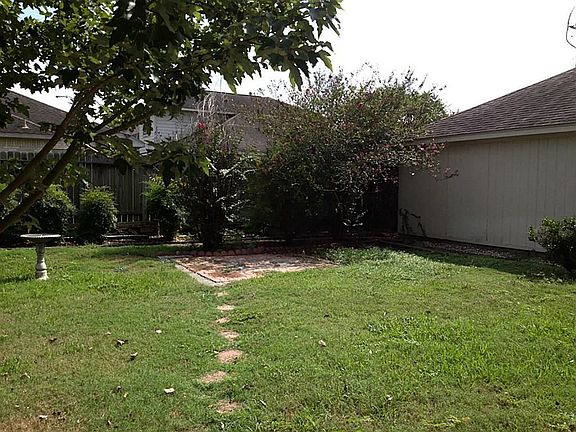 Backyard features bricked walkways and garden patio