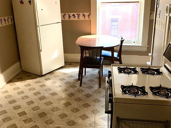 Other half of kitchen showing appliances and table.