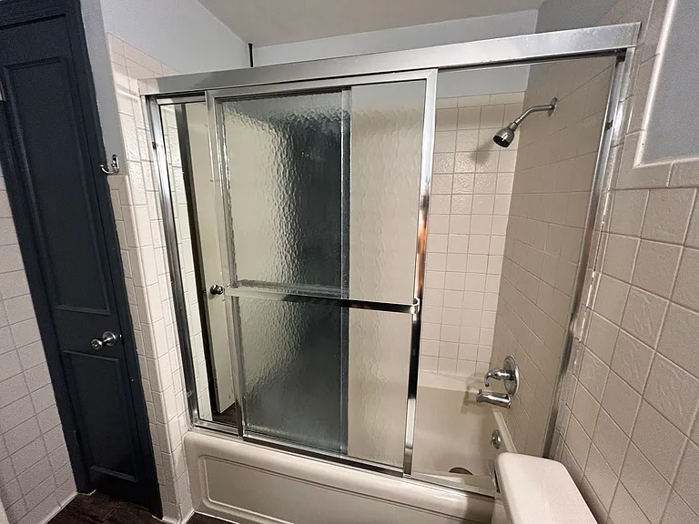 Bathtub with shower, mirrored sliding doors, deep linen closet