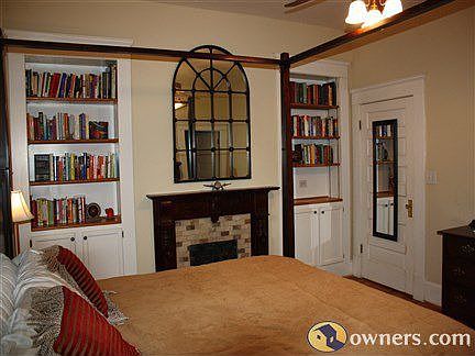 Fireplace and bookshelves add extra charm to master bedroom.
