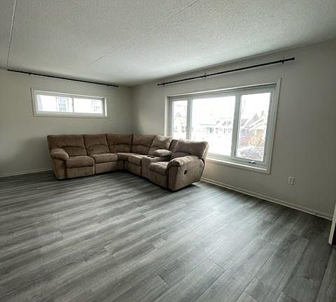 Living room with large front window and vinyl flooring.