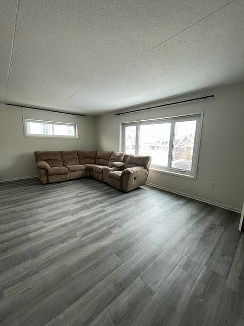 Living room with large front window and vinyl flooring.