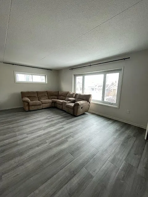 Living room with large front window and vinyl flooring.