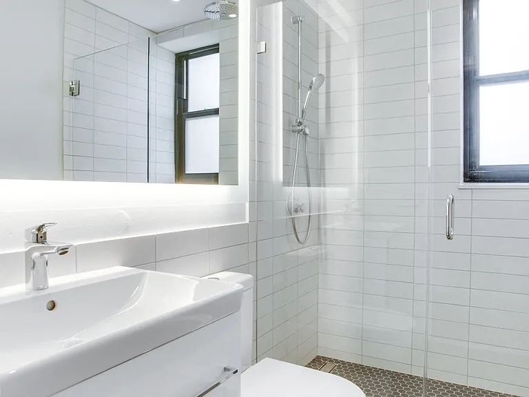 Luxury bathroom with chrome fixtures, natural light and rain shower