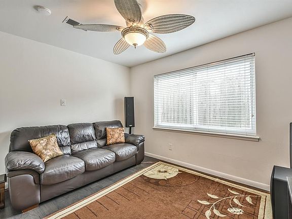 The formal dining/living room has wood floors, a ceiling fan and double paned windows.