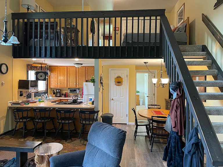 View of upstairs loft, shared kitchen, and shared dining room from shared living area