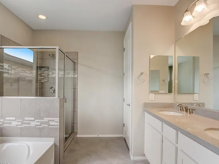 Primary bathroom with tiled shower, tub and Quartz countertops