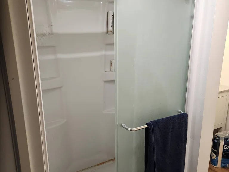 Apartment with closer view of shower with door open
