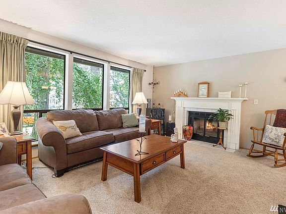Living Room Featuring Wood Burning Fireplace with Tile Surround and Elegant Painted Mantle.