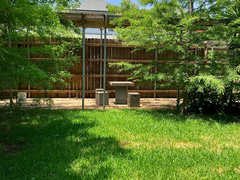 Shaded yard with pergola with picnic table