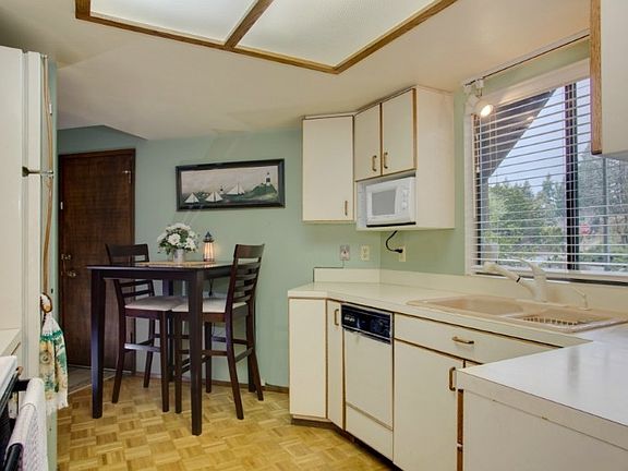 Kitchen has wood parquet floors & eating nook. Good counter & cabinet space. Window overlooks front yard.