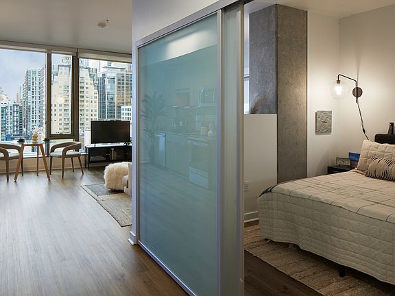 Spacious apartment bedroom with wood-style flooring.