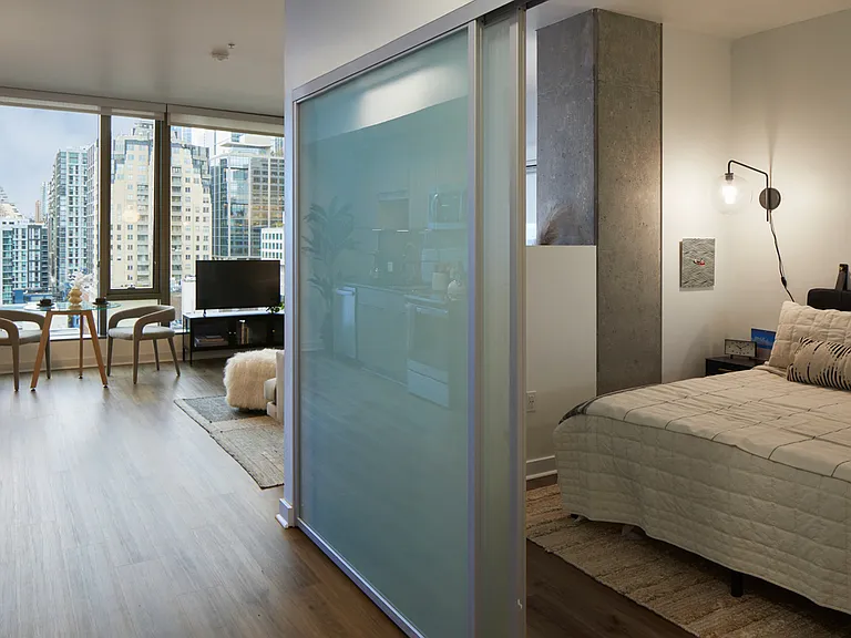 Spacious apartment bedroom with wood-style flooring.